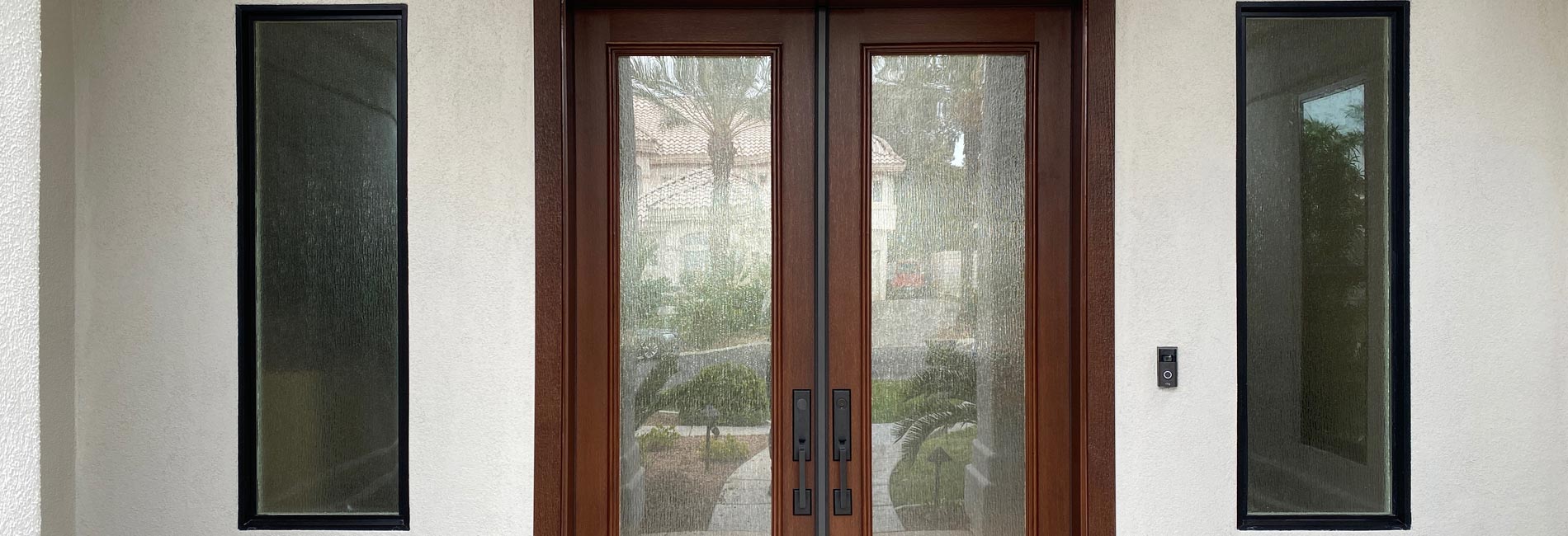 Beautiful wooden double french doors with panel windows on both sides in home entrance remodel