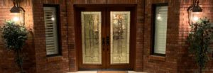 Double front door with patterned stained glass windows and hardwood frame