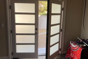French doors with horizontal panes leading to porch from house