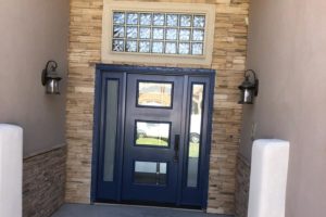 Front door with three window panels and textured glass transom window above as well as sidelites installed in Las Vegas